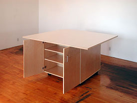 Tables for the art studio roll on wheels with cabinets below for storing art.