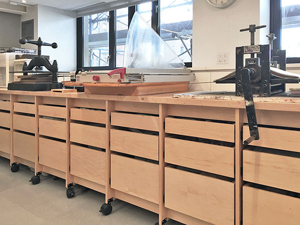 This art studio drawer system is mobile, it has 33 drawers and a 20.5' long x 30" wide art work table counter. Made for art students and their teachers to create and explore fine art in the classroom. The mobile rolling drawer table holds equipment for papermaking, printmaking, book binding, etching, paper cutting, and more. It is a rolling island for making art in the school art printmaking studio and classroom.