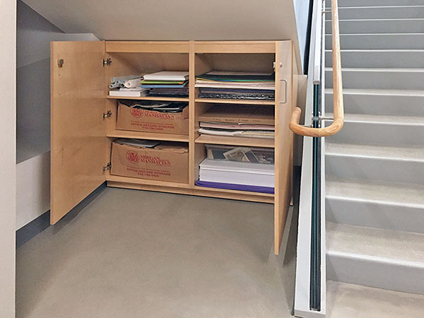 Under stair art storage cabinet has tapered top to match the stairs, made for storing art and art supplies, by Art Boards™.