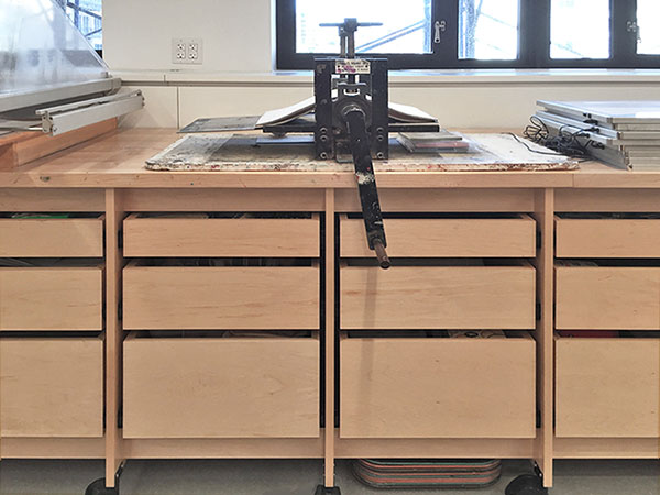 Art School printmaking studio has small etching press work station secured on top of the extra long art studio work table with art storage drawers below. Made in Brooklyn by Art Boards™.