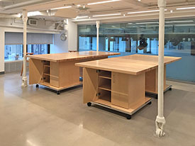 Art Studio mezzanine furniture with storage below rolls on wheels that lock securely in place.