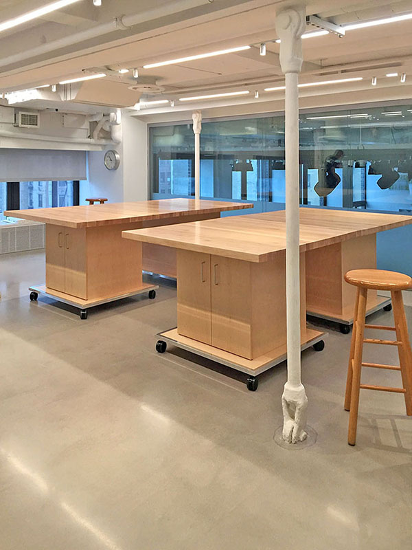 Four Art Studio Tables on an art school mezzanine are rolled together to create two large 48" x 96" tables. Tables roll on wheels and can be used individually as four separate 48" x 48" independent art school storage tables.